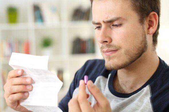 Ein Mann studiert die Packungsbeilage eines Antibiotikums gegen Prostatitis